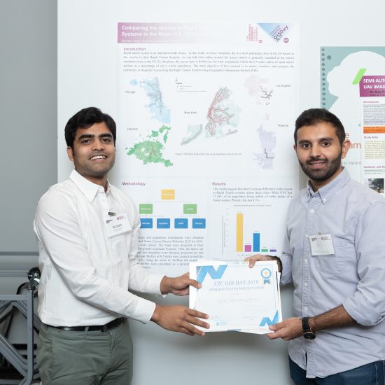 two people hold an award in front of an academic poster using GIS methods